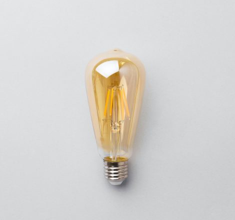 Light bulb on light grey paper background